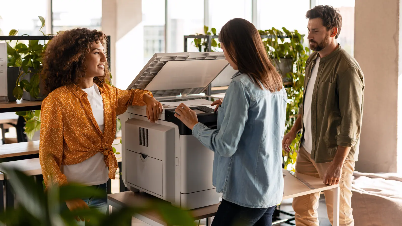 Collega's overleggen aan een multifunctionele printer op kantoor